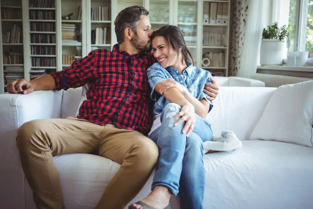 Couple échangeant un baiser rapide sur un canapé