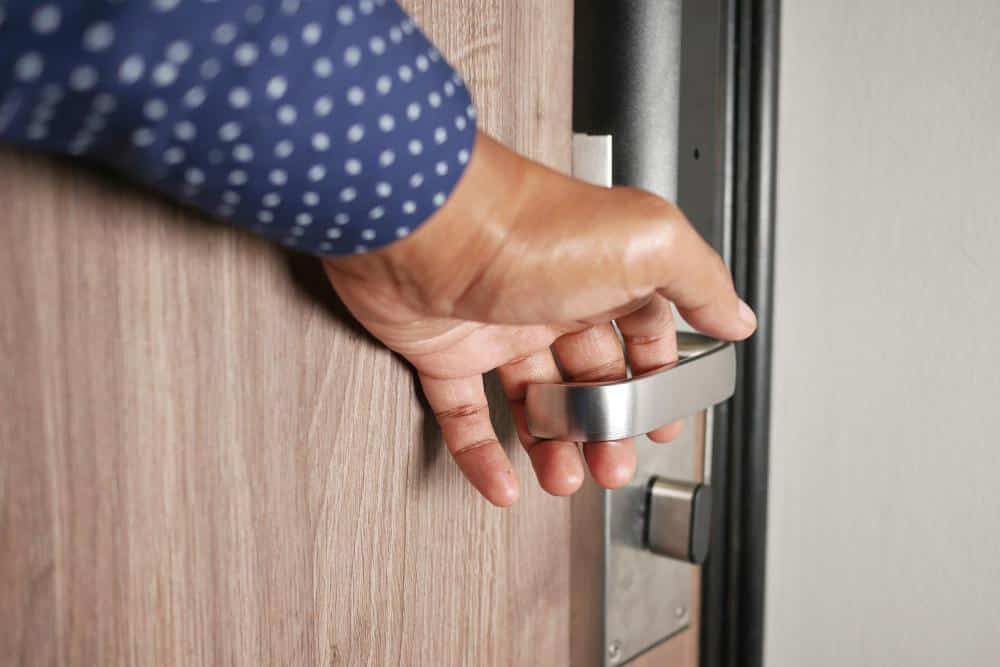 Main ouvrant une porte en gros plan
