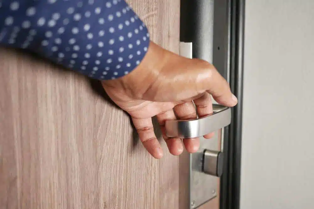 Main ouvrant une porte en gros plan