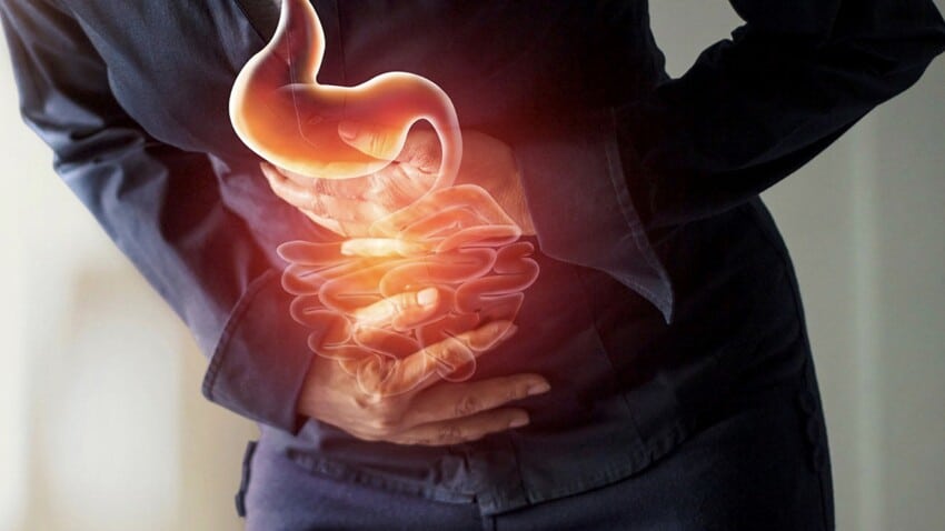 Femme se tenant le ventre avec inconfort digestif