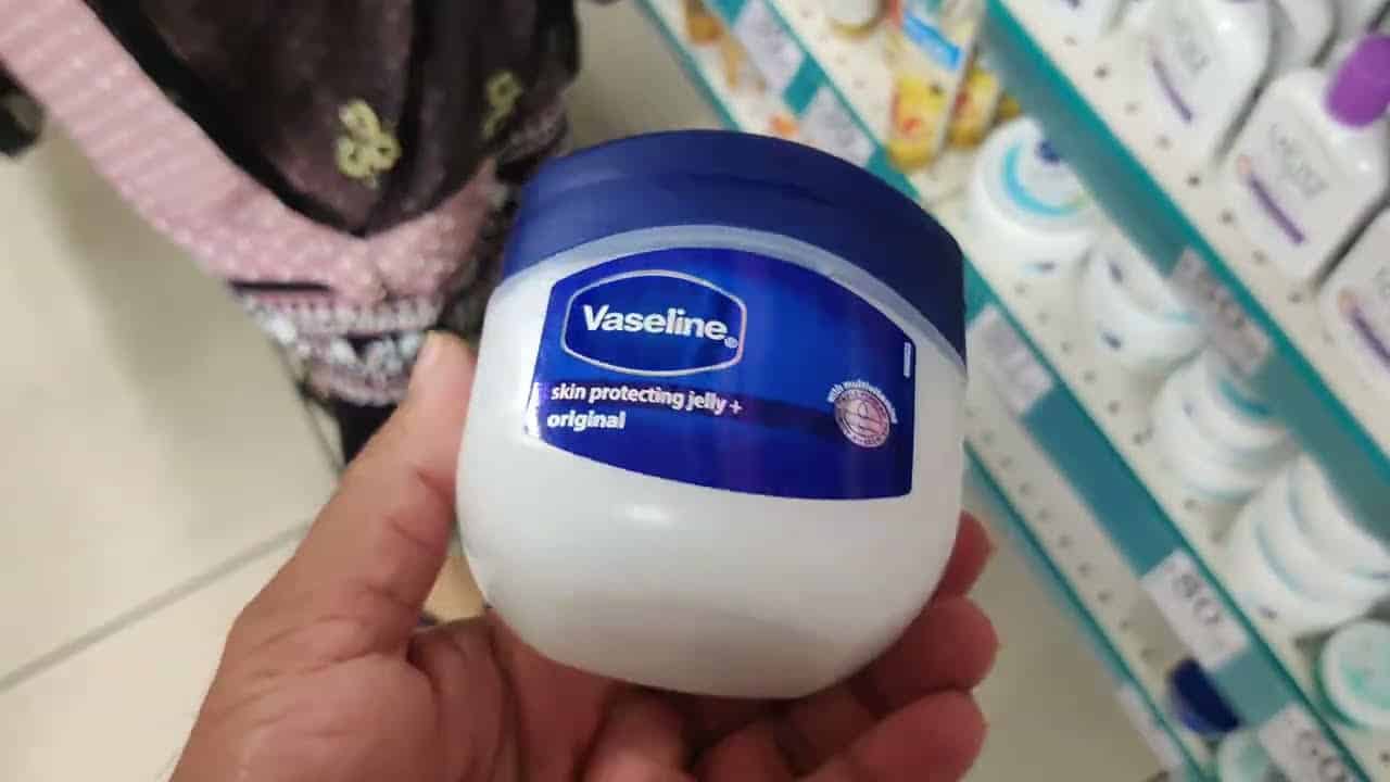 Pot de vaseline entouré de produits de beauté
