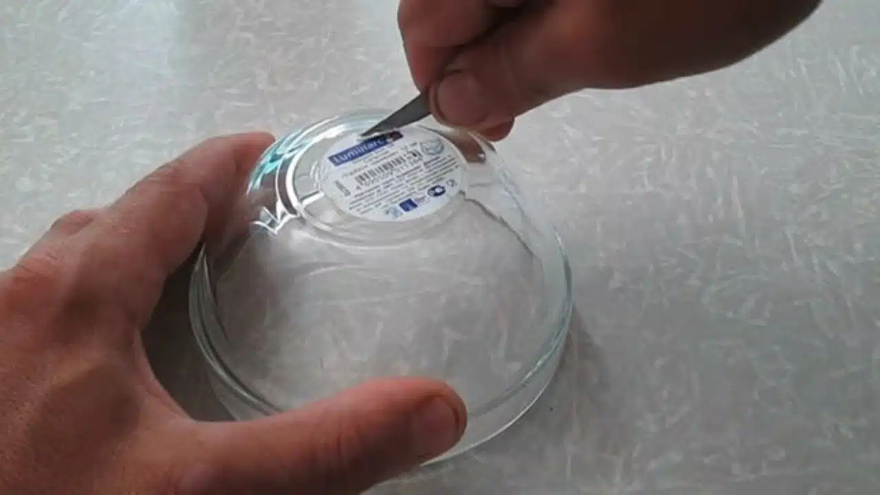 Gros plan sur des résidus de colle et un autocollant partiellement décollé