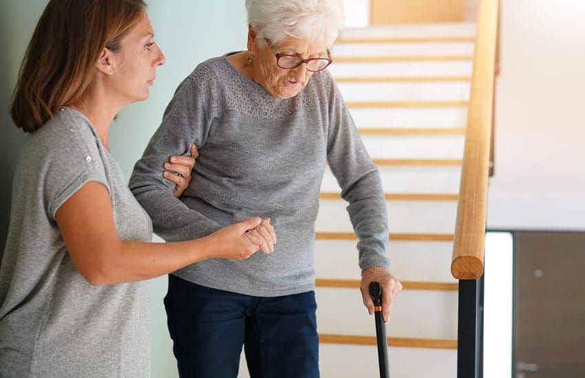Femme &acirc;g&eacute;e souriante portant des lunettes, tenant un livre