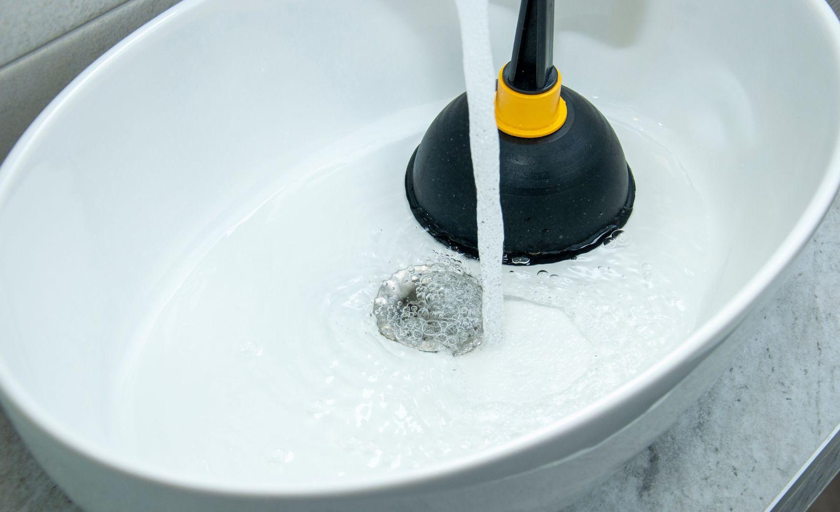 Utilisation d'une ventouse pour d&eacute;boucher un lavabo