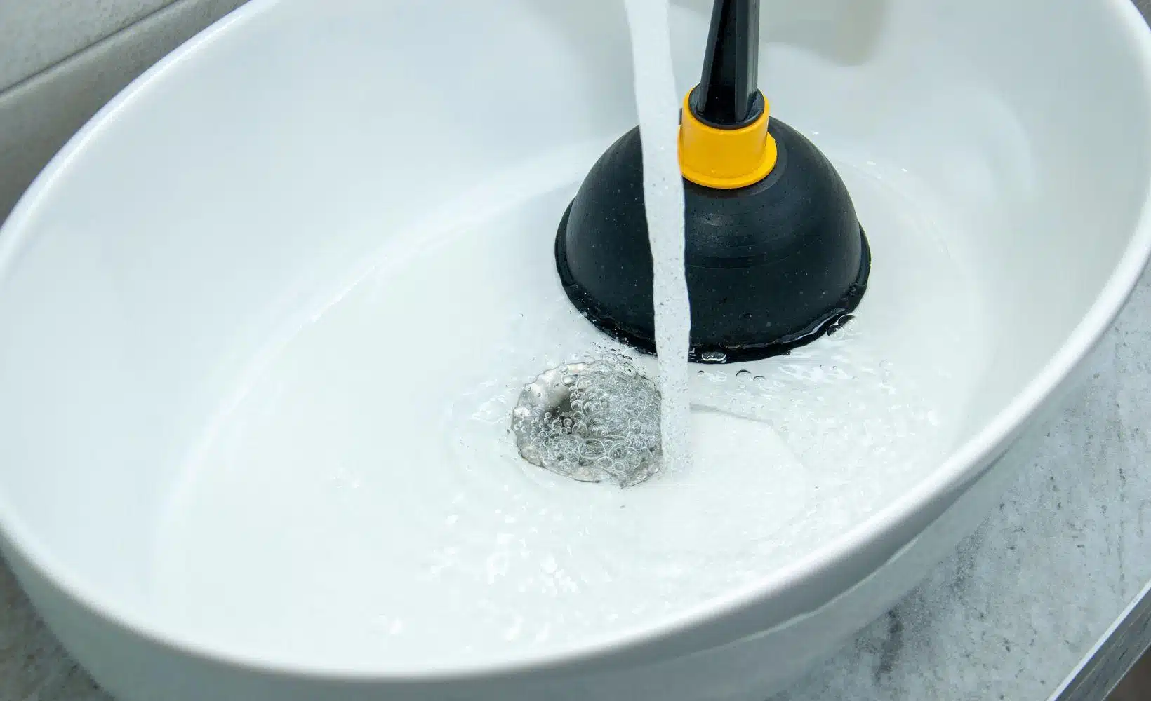 Utilisation d'une ventouse pour déboucher un lavabo