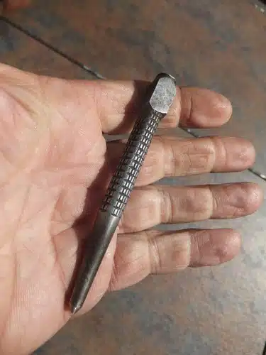 Poinçon à clous posé sur du bois