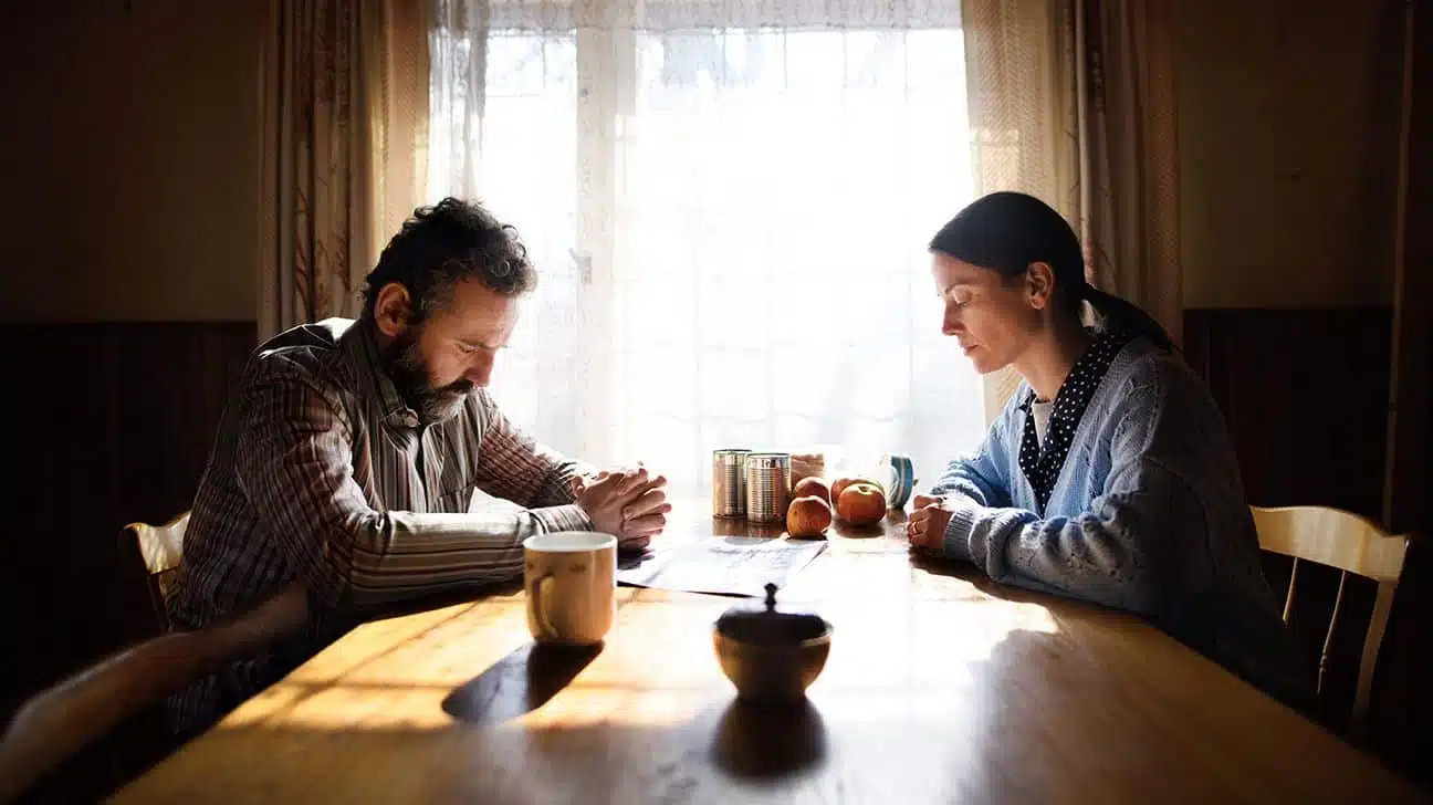 Couple d'âge mûr assis à table avec une expression triste