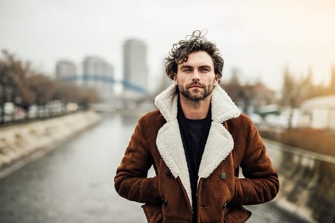 Homme &eacute;l&eacute;gant ajustant le bouton de sa manche, mains soign&eacute;es et posture assur&eacute;e