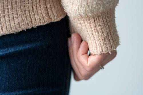 Détail de bouloches sur un pull en laine gris
