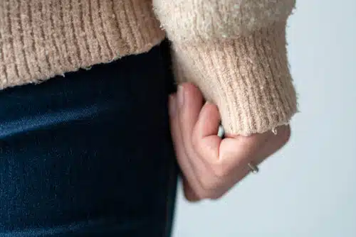 Détail de bouloches sur un pull en laine gris