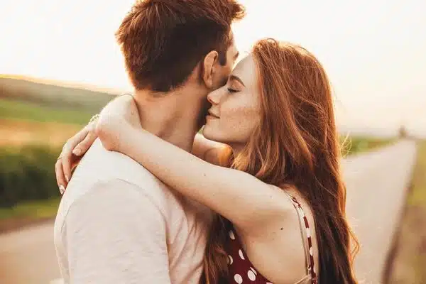Jeune couple s'enlaçant près d'une route