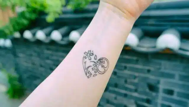 Tatouage de cœur stylisé sur avant-bras féminin