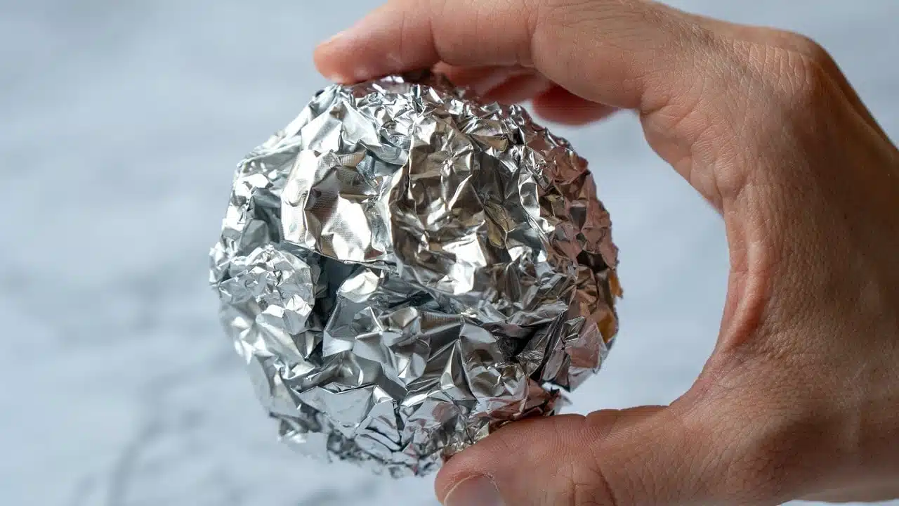 Feuille de papier aluminium appliquée sur la paroi intérieure d'un congélateur