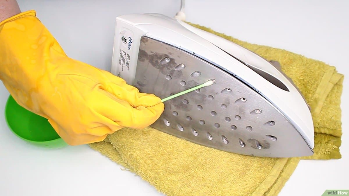 Nettoyage des trous de vapeur d'un fer avec un coton-tige