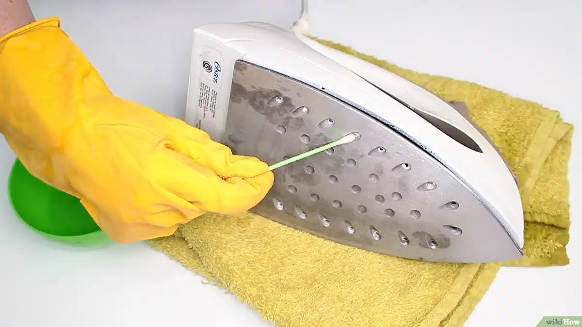 Nettoyage des trous de vapeur d'un fer avec un coton-tige