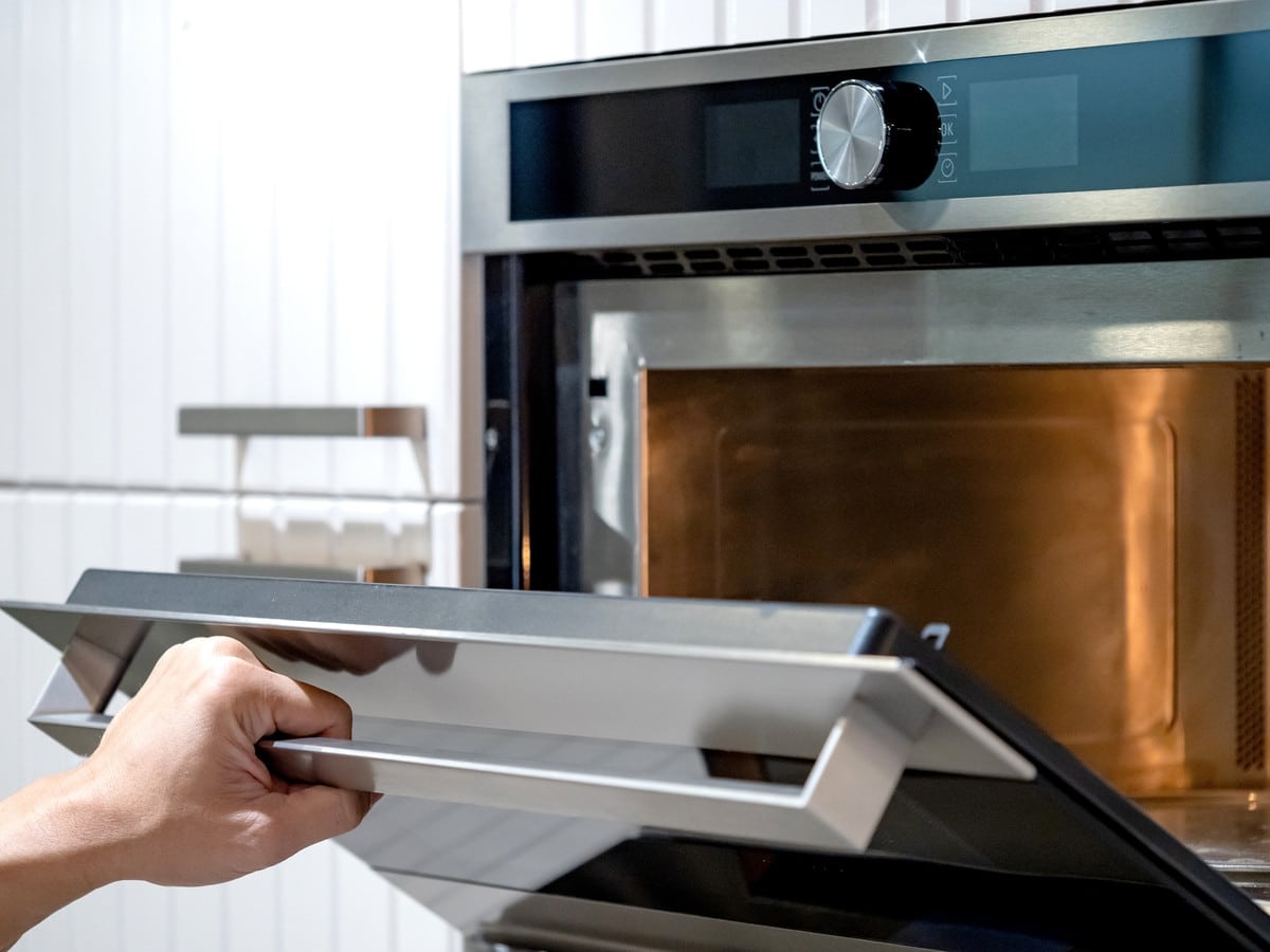 Femme nettoyant son four avec des produits adapt&eacute;s