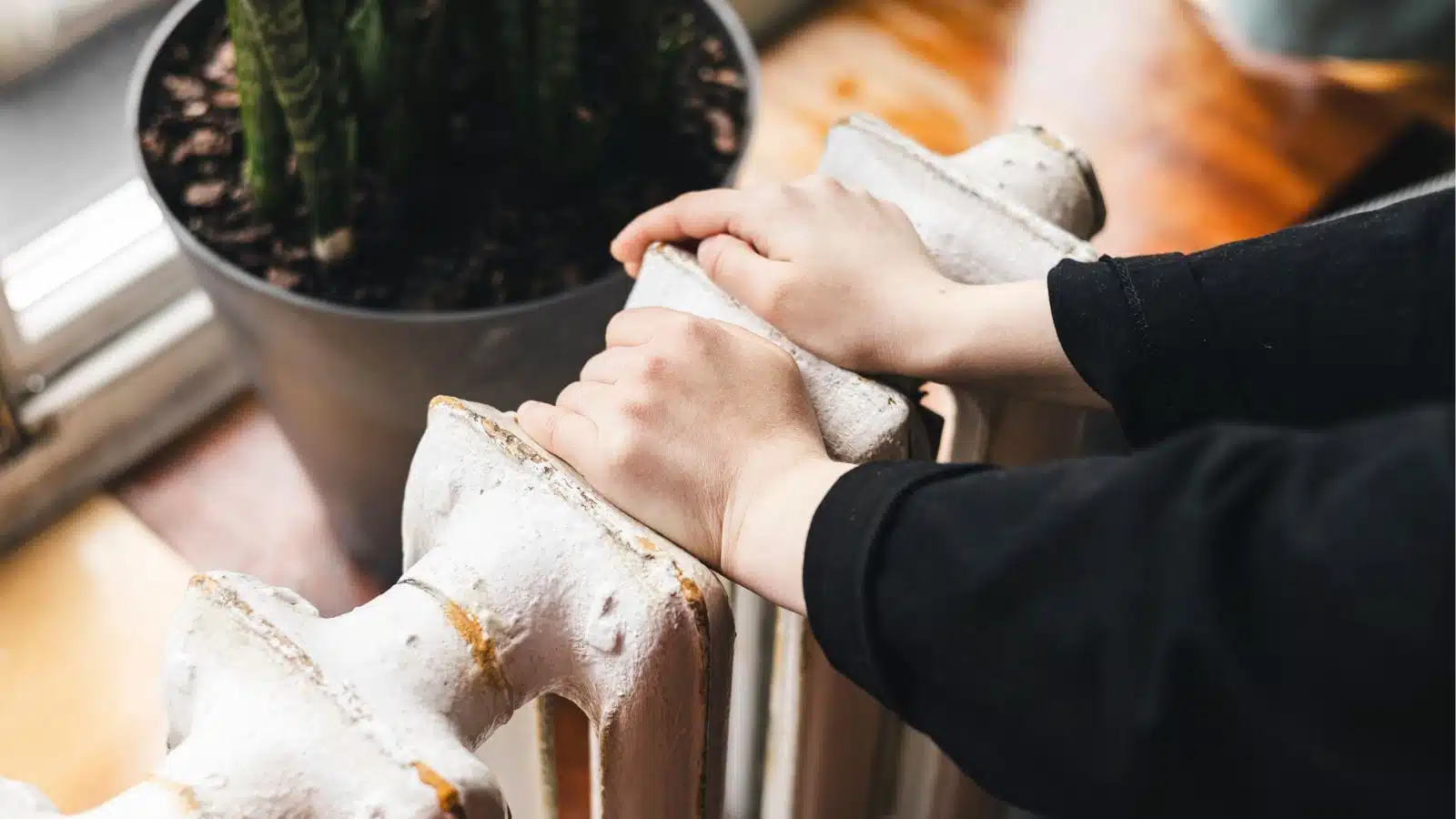 Femme réglant un thermostat connecté dans son salon
