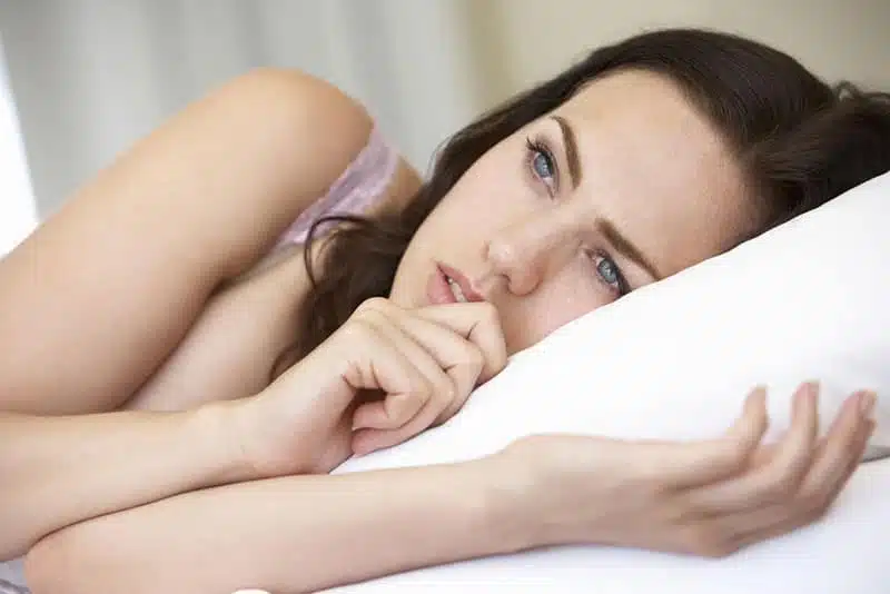 Femme allongée avec une expression triste