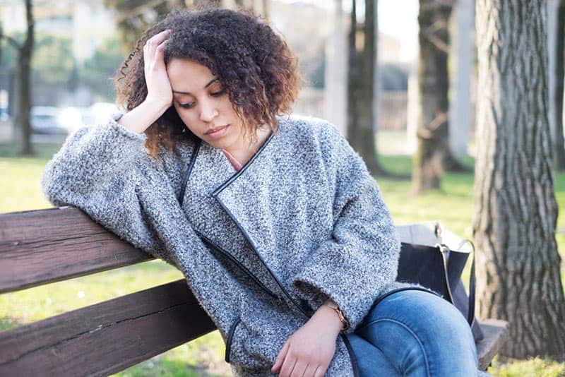 Femme assise avec une expression malheureuse