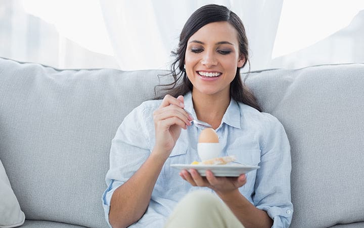 Femme mangeant un œuf