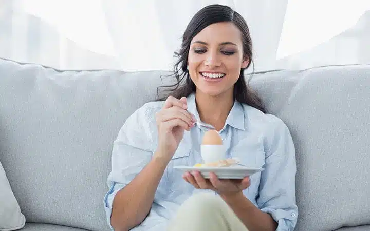 Femme mangeant un œuf