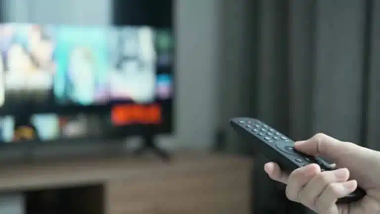 Femme utilisant une télécommande TV